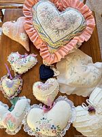 Group view of nine assorted heart pillows on table