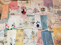 Overall view of entire group of embroidered linens laid out