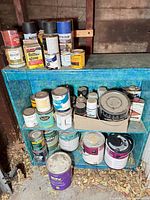 Full view of shelf with multiple paint, stain and spray containers