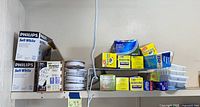 Shelf view showing Philips bulb boxes, smoke alarms, assorted wrap boxes and ice cube trays