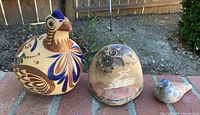 All three Tonalá pottery bird figurines arranged on brick ledge