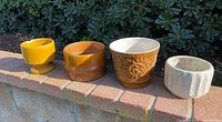 group shot of four pots on brick ledge