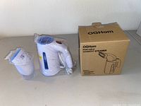 Steamer, measuring cup, and box on table