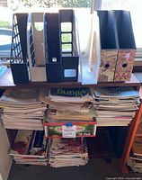 Top shelf view showing five plastic holders, two wood holders, and stacks of magazines below