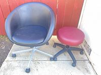 Black vinyl chair and maroon ottoman on concrete pad