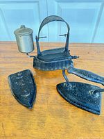Overview of three antique irons on table
