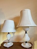 Two milk glass table lamps side by side on tabletop
