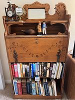 Full view of secretary desk with closed drop front and bookshelf