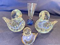 Group shot of two large bullicante birds, one small bird and bud vase