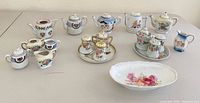 Overview of all miniature teapots, condiment sets, shakers and serving dish on table