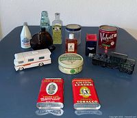 Group shot showing all tins, bottles, toy RV and train