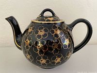 Left side view showing overall form, floral pattern and spout chip location