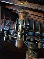 Overall view of hanging chandelier showing wood central column and three light arms