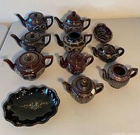 Group shot of all redware teapots and bowls