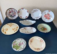 Group shot of ten porcelain plates and platters on table