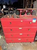 Front view of red 4-drawer dresser with brass-tone pulls