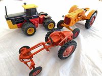All three die-cast tractor models grouped together on white surface