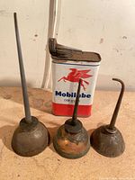 Front view of three oil cans and Mobilube can