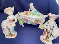 Group view of covered dish and two Ucagco figurine vases