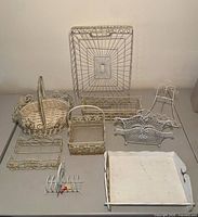 All nine white metal items and wooden tray on table