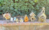 Lineup of all five wood birdhouses and two bird figures