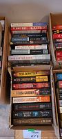 Two cardboard boxes of paperback novels, spines visible
