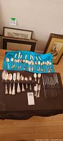 Full lot overview showing souvenir spoons, serving spoons, forks and spreaders
