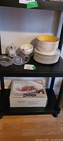 Dinnerware stacks, crystal pieces, boxed Pyrex roaster on shelving
