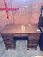 Front view of wood pedestal desk in basement setting