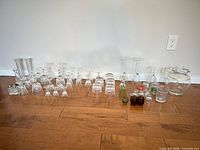 Full lot arrangement of assorted glasses, pitcher and shakers on floor