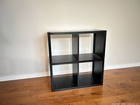 Front view of black 2x2 cube shelf showing four cubbies