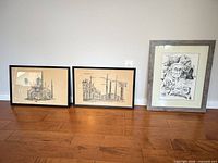 Group shot of all three framed drawings leaning against wall