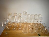 Full set of gold-rimmed glasses and decanter on table