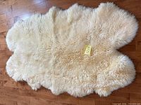 Front view of cream sheepskin rug showing pile and outline