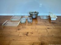 Full lot showing glass bakeware, stainless bowls, ceramic loaf pan