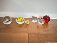 All six paperweights lined up showing relative sizes and designs