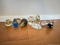 Full lineup of nine glass pieces on wood floor