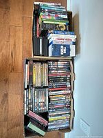Two cardboard trays filled with DVDs and Blu-rays