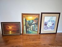 Group shot of three framed artworks against wall