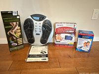 Four boxed medical devices and foot massager displayed