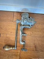 Full view of grinder showing clamp screw, crank and wooden handle