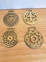 Front view of all four horse brasses laid out
