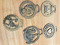 Front view of all five brass plaques on wood surface