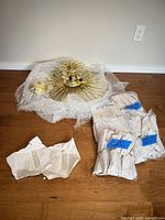 Disassembled chandelier frame, canopy, chain, and packaged prisms