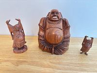 Front view of all three wooden Laughing Buddha figurines