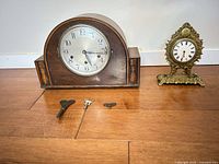Both mantel clocks and three keys on floor