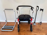 All four items standing side by side: bed rail, rollator walker, quad cane, grabber
