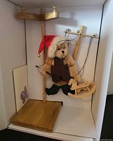 Bear marionette on stand with controller and rocking horse inside box