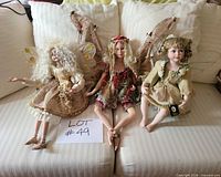 Group image of all three porcelain fairy dolls on sofa