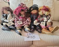 Group shot of four Little Souls dolls seated on couch with Lot sign
